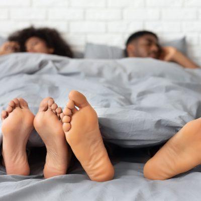 Couple sleeping with feet out